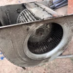 Dirty AC blower wheel and scroll cage before cleaning during a tune-up.