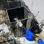 AC condenser with panels removed being washed during a tune-up.