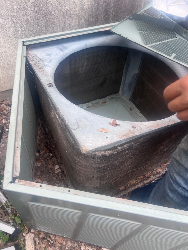 Older outdoor AC condenser with dirty condenser coil reducing cooling efficiency