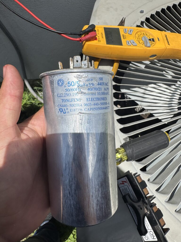 Technician testing a failed AC run capacitor during an air conditioner repair in Edinburg, Texas