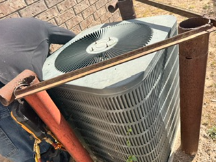 Older Goodman air conditioning condenser being inspected for AC efficiency and system performance